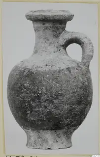 Pottery White Painted VII vessel with a single loop handle