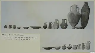 Pottery from Tomb 88 at Marion: two rows of jugs, bowls and dishes set out for photographing