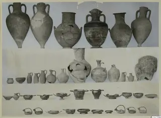 Pottery from Marion Tomb 67 in rows: tall two-handled jars, small jugs, bowls and dishes on a pale ground.