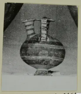 White Painted I jug from Marion, with two tall necks joined by a bar across the top and a rounded body