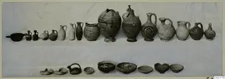 Pottery from Marion, Tomb 42: jugs, juglets, bowls and lamps laid out in two rows on a pale cloth