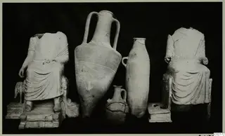 Terracotta statuettes and pots from Marion Tomb 30: two seated headless figures flanking three vessels