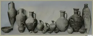 Pottery vessels from Marion, Tomb 53, arranged in a row against a draped cloth