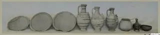 Row of nine pottery vessels from Marion, Tomb 51: three flat plates, three painted jugs and three smaller vessels.