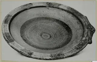 Shallow bowl with concentric painted rings in the centre and a lug on the rim, from Marion
