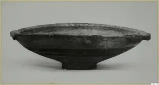Bichrome-Red bowl with two small side handles and a low ring foot, photographed from the side on a pale surface.