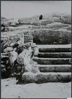 Stone steps and rubble walls at Vouni Palace, with a dark opening in a wall behind