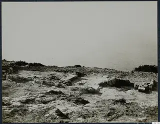 Low stone foundations and ruined walls on a rocky headland at Vouni, with the sea beyond