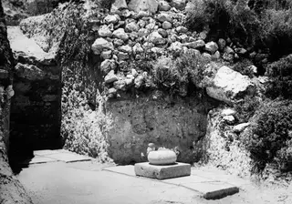 Trench 1 at Loures with a column base in place on a flat slab floor, beside a rubble stone wall