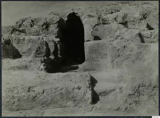 Excavated stone walls at the Vouni palace, with a dark arched opening at centre