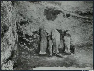 Stone sculpture fragments in situ in Room 117 at Vouni, set against the excavated back wall
