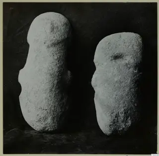 Two worked stone objects from Petra tou Limniti, standing side by side against a dark backdrop