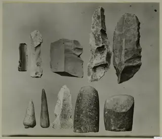Ten worked stone objects in two rows, including blades, flakes and rounded tools, from Petra tou Limniti
