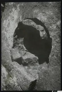 Rock-cut press in Room XXI at Kition: a rounded hollow in bedrock with stone blocks at its base.