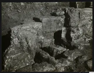 Excavated stone blocks and wall remains at Kition, room 10, with dark openings between them