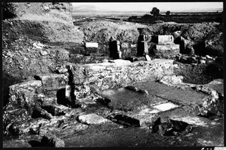 Excavated room at Kition with stone walls and foundations, a flat plain and hills beyond