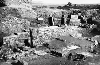 Excavated room 11 at Kition with stone walls, column bases and a paved floor in the foreground.