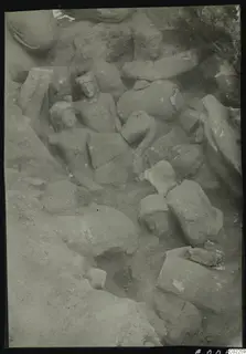 Accumulation of stone statues and heads lying among rubble in an excavated corner at Kition