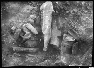 Accumulation of broken stone sculptures and fragments lying in an excavated pit at Kition