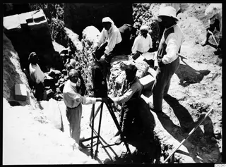 John Lindros filming at the excavation in Kition, with workers around a tripod-mounted camera