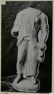 Headless limestone statue from Vouni in a long pleated garment with a belt