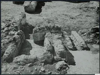 Excavated stone walls and blocks in bare earth at the palace at Vouni