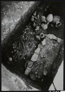 Tomb 22 at Amathus with pottery vessels and scattered stones lying in situ in the excavated tomb.