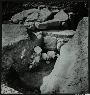 Excavation at Amathus with pottery vessels lying among large stone blocks in a trench