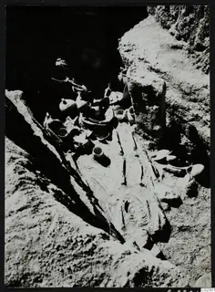 Skeleton with pottery vessels in a rock-cut tomb at Amathus during excavation