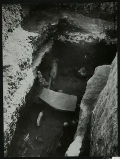Excavation trench at Amathus with pottery vessels and large stone slabs lying in the cut