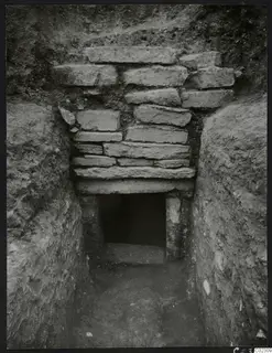 Tomb 24 at Amathus: a cut passage leading to a stone-blocked wall with an open doorway into the tomb chamber.