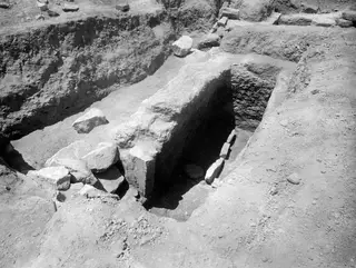 Tomb 14 at Amathus after excavation, showing a cut passage with large stone blocks leading to a dark opening