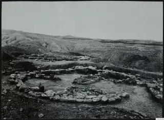 Excavated stone foundations of a building at Kythrea, with hills in the background