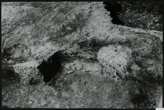 Excavated ground at Kythrea with pale stones and a dark cut in the soil