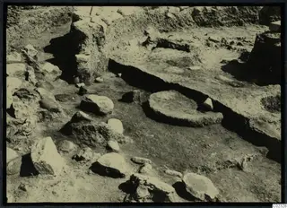Excavation at Kythrea showing stone walls, a circular stone base and a long flat stone ledge in the ground