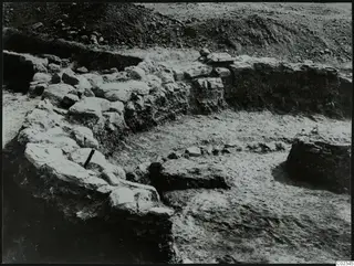 Excavated stone walls at Kythrea, with a spoil heap of earth and stones behind them