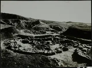 Excavation at Kythrea showing low stone walls and foundations in a trench on a hillside