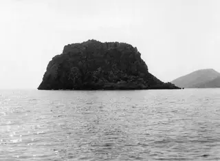 Petra tou Limniti, a steep rocky island rising from the sea, seen from the west.