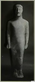 Limestone statue of a standing figure from Kition, shown full length against a dark background.