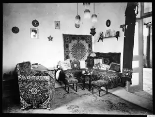 Salon interior of a house at Kition with a sofa, armchairs, rugs and wall hangings