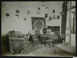 Salon interior at Kition with a sofa, upholstered armchair, low stools and hanging lamps