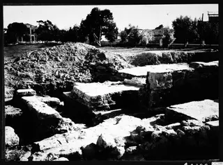 Excavated area at Bamboula, Kition, with exposed stone walls and a heap of earth behind them