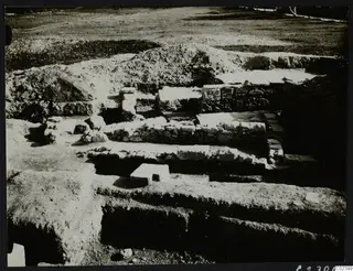 Excavated stone walls and trenches at Bamboula after the excavation, with spoil heaps behind them.