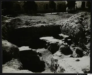 Excavation at Kition showing the western end of a temple substructure of cut stone blocks in a trench.