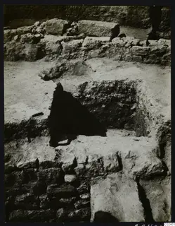 Excavated stone walls at Kition, with the floor of Room 4 broken through to leave a dark opening.