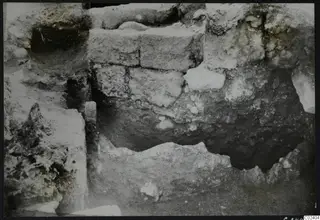 Excavated ancient walls at Kition, built of rough stone blocks in a trench.