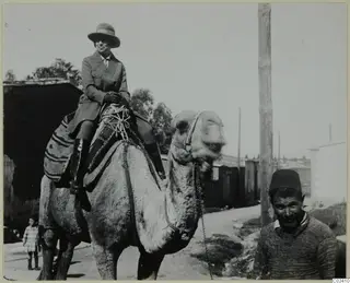 Vivi Gjerstad riding a camel along a street in Nicosia