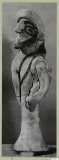 Terracotta figurine from Ayia Irini of a standing figure in profile, with painted face and dark chest bands