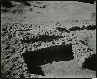 Excavated stone wall and loose stones at Ayia Irini, seen from above during excavation.