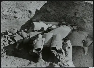 Broken figures and vessel fragments lying in situ in excavated soil at Ayia Irini